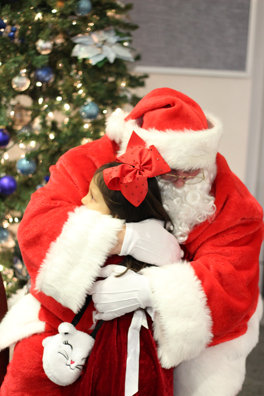 Santa and a little girl hugging.