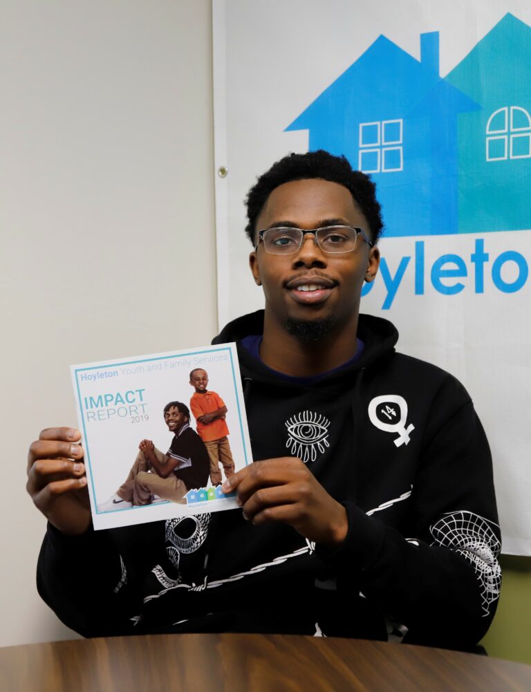Fryday holding a 2019 Impact Report where he was featured on the cover.